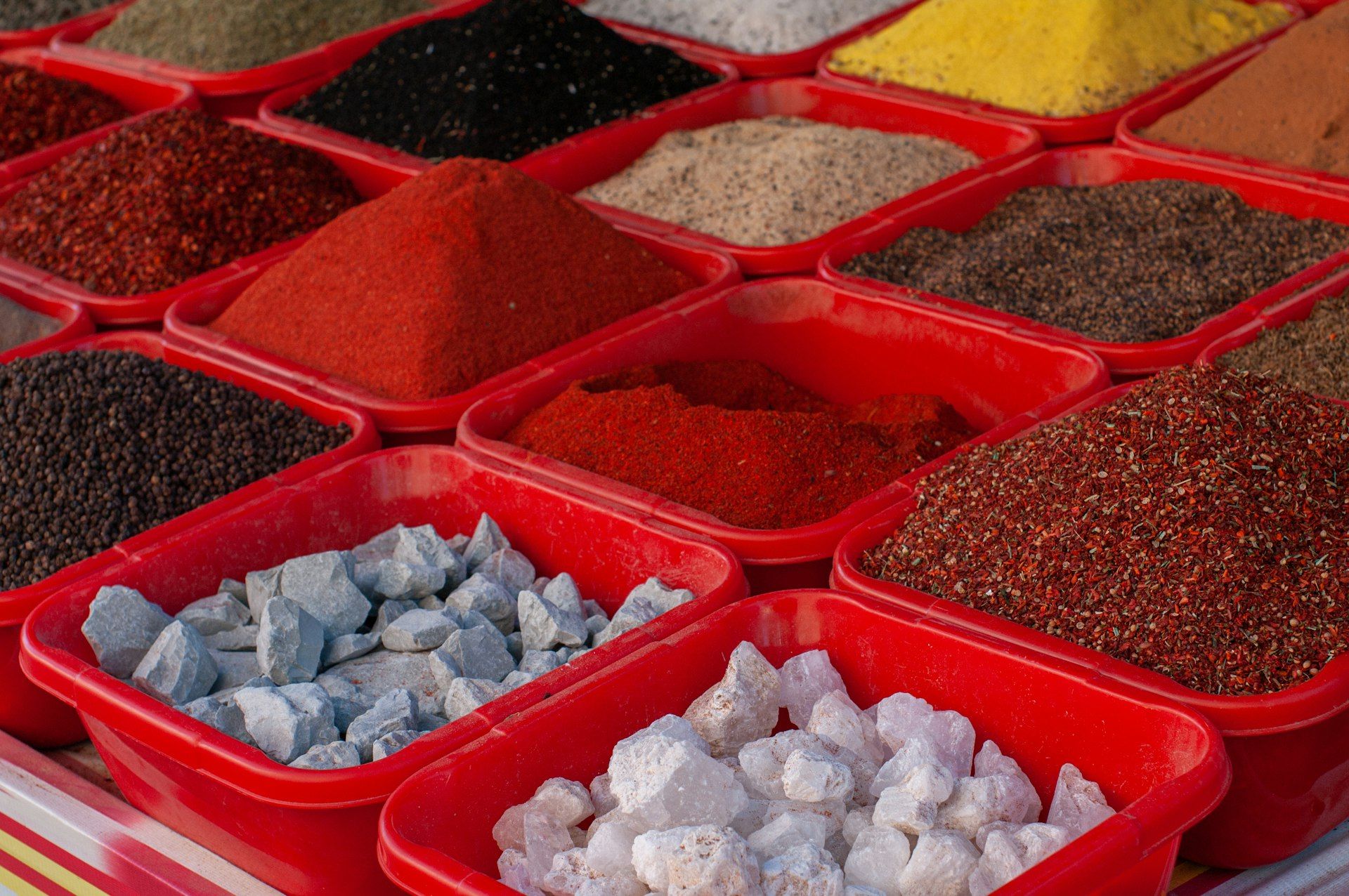Spices and herbs piled in red trays at Chorsu Bazaar in Tashkent