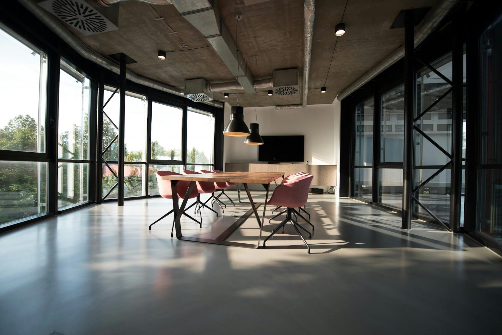 An empty modern office with a long table and floor-to-ceiling windows
