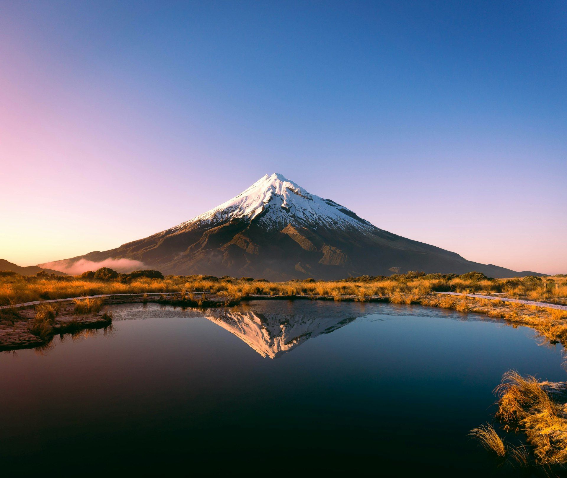 Mount Taranaki in New Zealand reflected in the Pouaki Tarns at golden hour