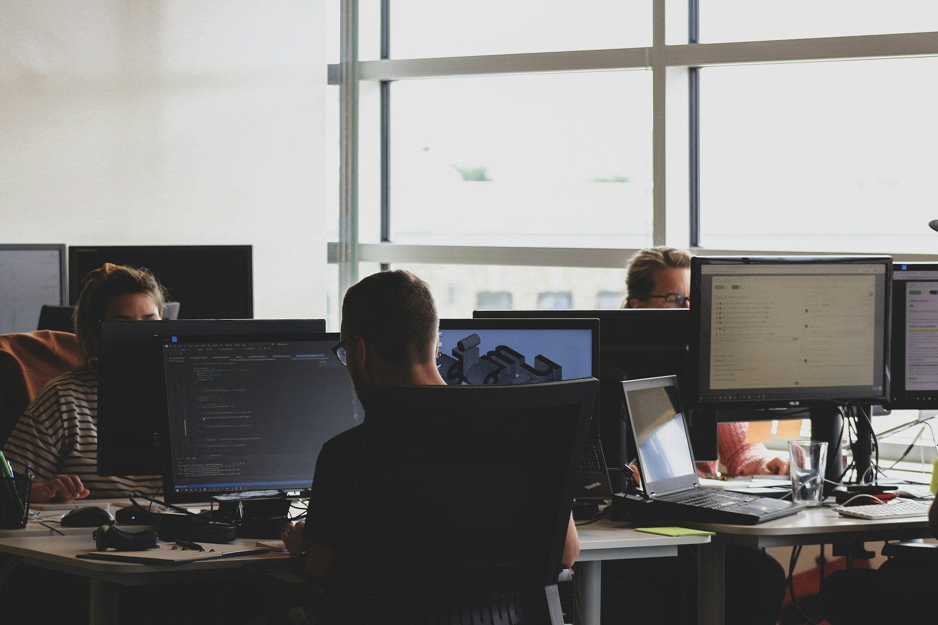 A team working at computer screens in a bright open-plan office