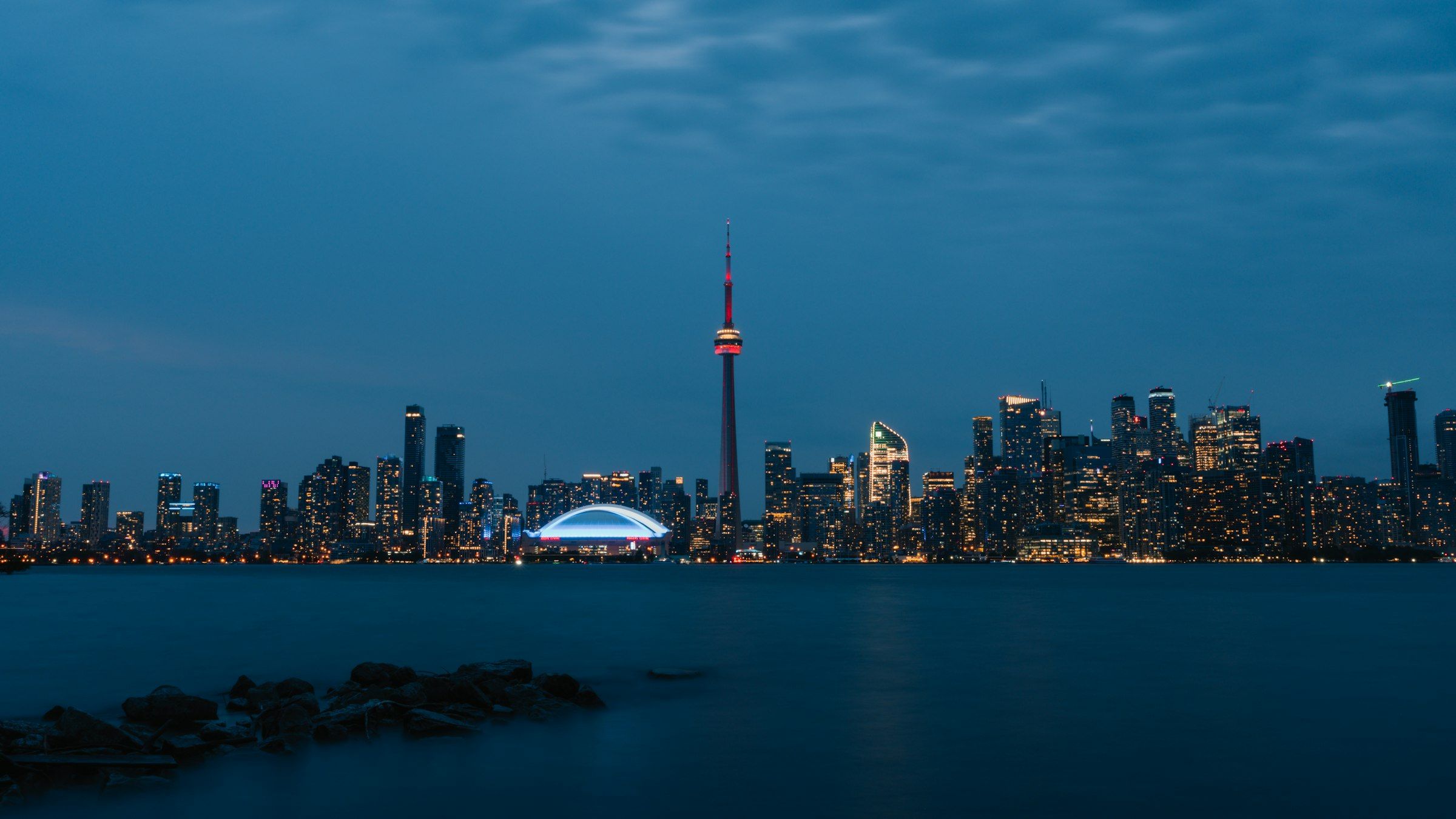 The Toronto skyline and CN Tower across Lake Ontario in the evening
